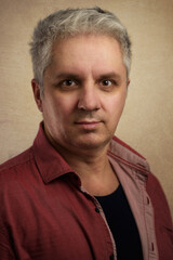 Fototapeta premium Portrait of a casual Caucasian Businessman in his forties dressing for work in a coral flower coloredshirt