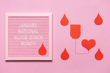Text JANUARY NATIONAL BLOOD DONOR MONTH with red drop on pink letterboard. Annual national red...