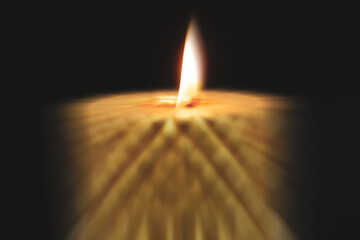 Distorted image of burning christmas candle, dark background