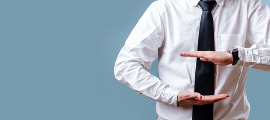 The businessman's hands in a white shirt and tie present something. On the blue background