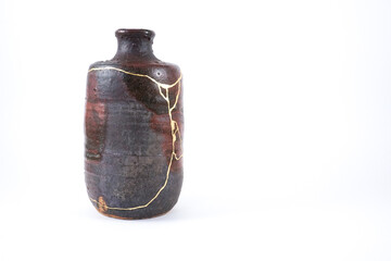 Kintsugi brown sake bottle with gold cracks, real gold wabi sabi Kintsukuroi, Japanese artisan work. Kintsugi, the beauty of imperfections,
