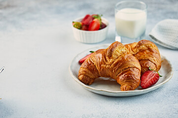Croissant on a plate with strawberries and a glass of milk - Powered by Adobe