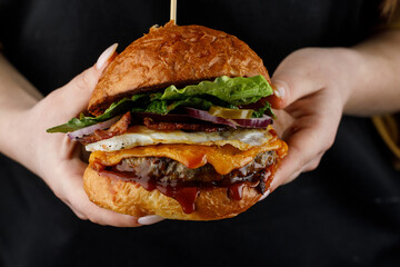 Girl holding juicy fresh tasty burger