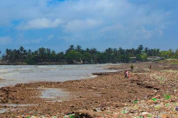Sea Pollution: Garbage dumped in the Sri Lankan Sea near Colombo. women collects plastic things in...