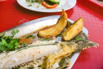 Fried fish with potato close up, half eaten
