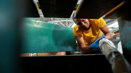 Fototapeta na wymiar Young african american man putting cups into waste machine