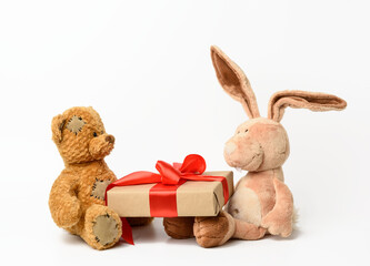 Fototapeta premium brown teddy bear and rabbit holding a box with a gift