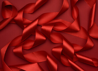 curled red silk ribbon on a red background