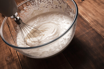 Whisking of cream ingredients for cake. Motion blur photo for bakery concept background.