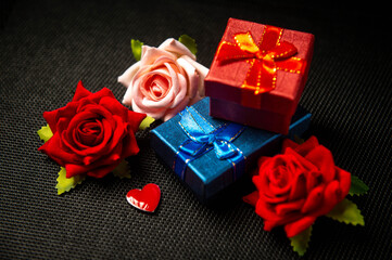 Gift boxes are on the table next to the roses. Red heart symbol of love. Gifts for the holiday. Gifts for Valentine's Day. International Women's Day. Decoration.