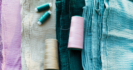 
Four pieces of muslin and a thread of the same color. Backgrounds for seamstress needlework and garment textile production. Sewing and hobbies.