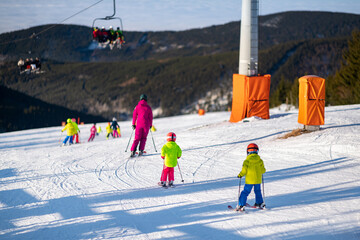 Group of children on the ski slope during the ski school lesson.