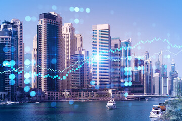 Fototapeta premium Skyscrapers of Dubai business downtown. International hub of trading and financial services of Western Asia. FOREX graph and chart concept. Double exposure. Dubai Canal waterfront.