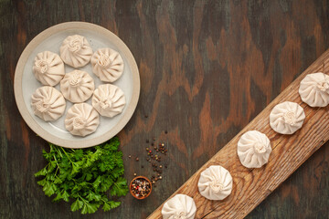 National Georgian cuisine. Raw Khinkali with meat. Khinkali on a ceramic plate. Top view