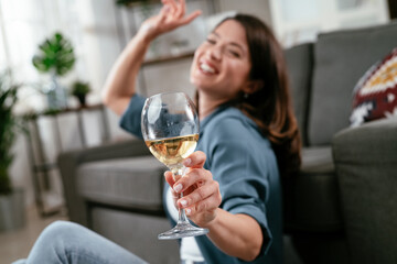 Beautiful woman drinking wine. Young woman celebrate with wine at home