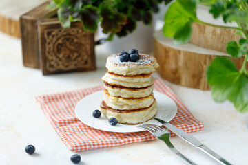 Pancakes with berries and powdered sugar in a plate on the table.