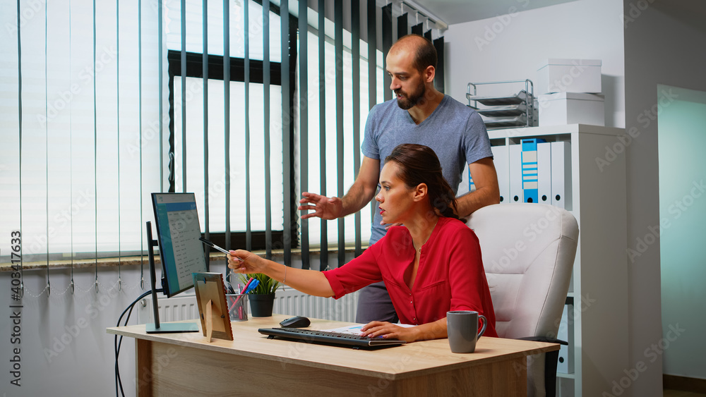 Poster team searching the best solution in front of computer in modern office room. coworkers discussing wo