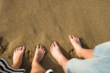 Beach. Photo of a pair of lovers-feet on a beautiful golden sand-a man and a woman.