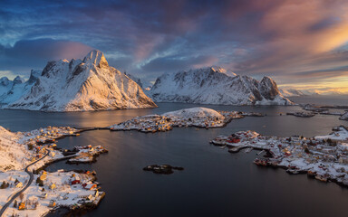 Panoramic view of Reine village surrounded with fjords and snow covered mountains at amazing sunrise, Lofoten islands, Norway