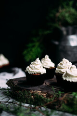 Chocolate cupcakes with creamy cream on a gray table