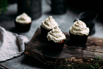 Chocolate cupcakes with creamy cream on a gray table
