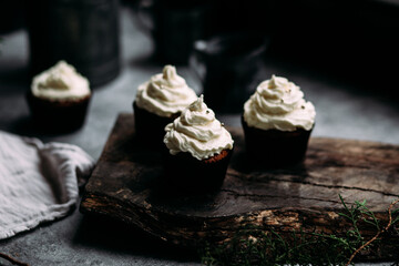 Chocolate cupcakes with creamy cream on a gray table
