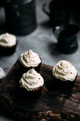 Chocolate cupcakes with creamy cream on a gray table