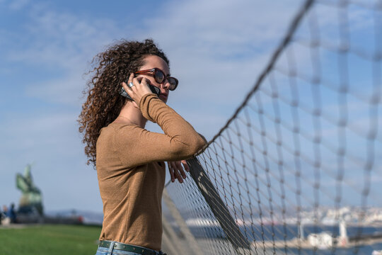 Jeune femme parle au t&eacute;l&eacute;phone dans les jardins du palais du Pharo