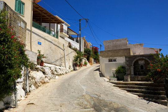 Flowers in pots near the wall, small houses and road leading to the city.