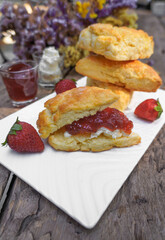 Scones and Strawberry Jam, Clotted cream in a white plate on a wooden table