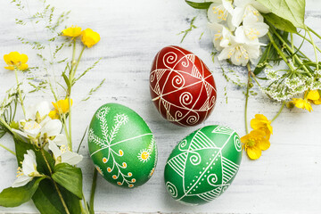Red and green Easter pysanka eggs with flowers - obrazy, fototapety, plakaty