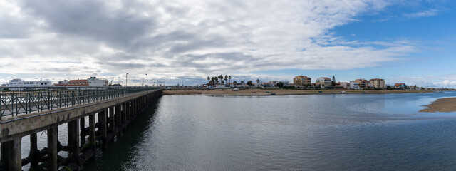 panorama view of the old bridge leading to Faro Island and beach on the Algarve of Portugal