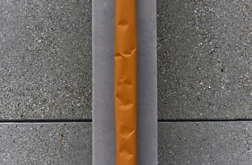 Cement surface with different textures. Large indented orange tube in the center