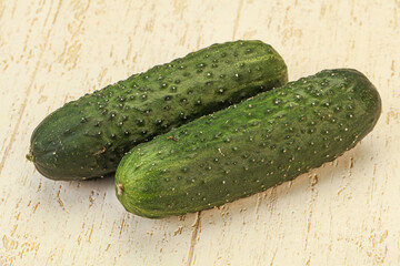 Green fresh cucumbers over background