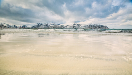 Lofoten Islands. Sandy beach in the background of the mountains.