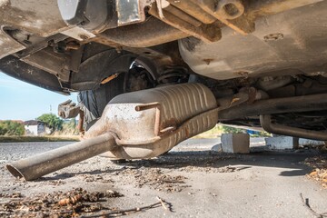 Car exhaust (muffler) fallen off a car - forgotten car on street