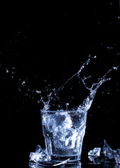 Splashes of water. Falling ice cubes into a glass of water
