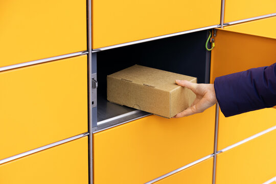 Send Or Receive Parcel With Self Service Post Terminal Machine. Hand With Package