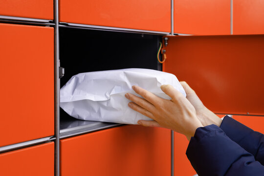 send or receive parcel with self service post terminal machine. hand with package