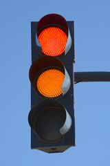 Traffic light with red light above and yellow light