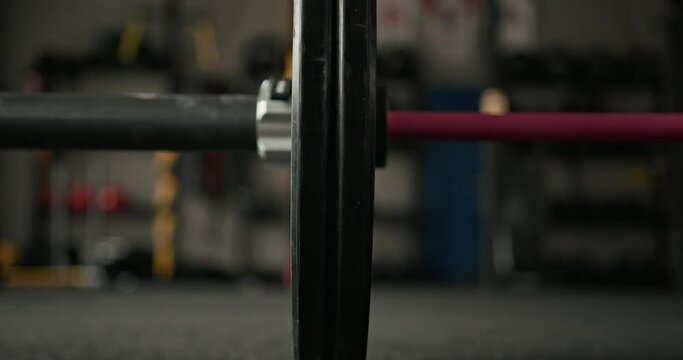 Close-up view of falling barbell. Woman drop barbell. Jumping barbell in gym.
