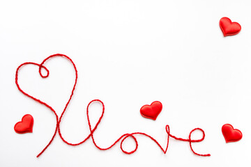 Valentine's day concept. Red heart and word love made from woolen rope on white background with copy space.