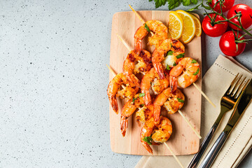  Grilled prawns on wooden skewers, shrimp kebab. Top view, free space for text