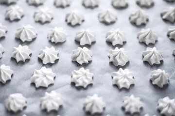 Confectioner prepares meringue in the kitchen. meringue on a baking sheet.