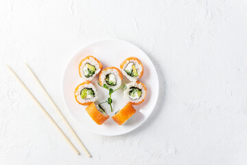 Sushi rolls for Valentine's Day in the form of a heart on a white plate. Horizontal orientation, top view.