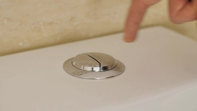 finger pushing button and flushing toilet