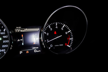 Close up shot of a tachometer in a car. Car dashboard. Dashboard details with indication lamps. Car instrument panel. Dashboard with speedometer, tachometer, odometer. Car detailing.