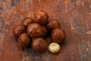 Brown macadamia nut heap over background