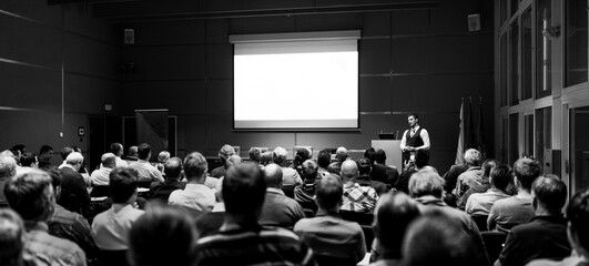 Speaker Giving a Talk at Business Meeting. Audience in the conference hall. Business and Entrepreneurship concept. Black and white.
