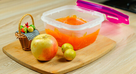 Apple orange color jam in a tiffan box with an apple and a basket